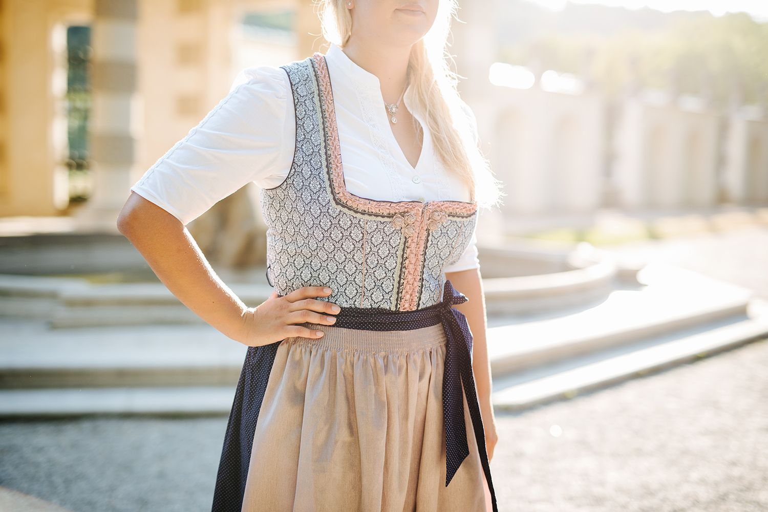 Dame in gemustertem Dirndl mit beigem Rock
