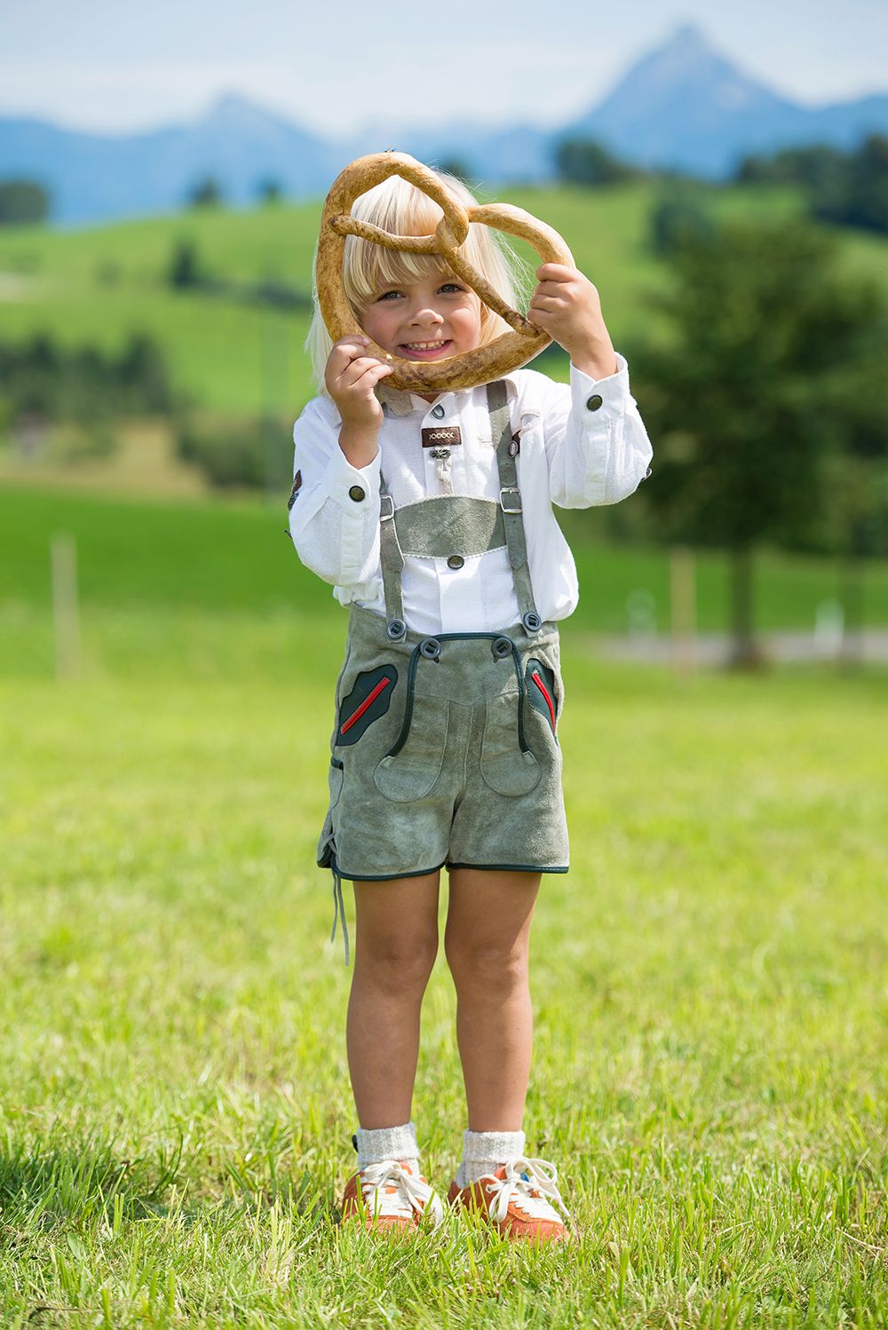 Junge in Lederhosen auf einer Wiese